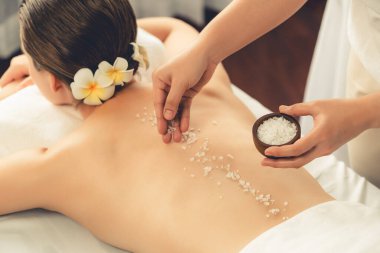 Lüks spa salonlarında sıcak mum ışığında cilt bakımı yaptıran kadın müşteri. Sağlık Spa vücut fırçasında tuz temizleme güzellik tedavisi. Sessiz.