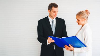 İki iş adamı toplantı odasında proje stratejisi hakkında konuşuyor. İş adamı, iş yerinde iş arkadaşlarıyla proje planlamasını tartışırken aynı zamanda mali raporla ilgili sohbet ve tavsiyelerde bulunuyor. Jivy