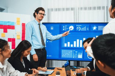 İş adamı, finansal rapor veri analizi veya pazar eğilimi gösterisiyle iş sunumunu şirketin gelecekteki yönetiminde stratejik planlama için büyük bir TV ekranında sundu. Habiliment