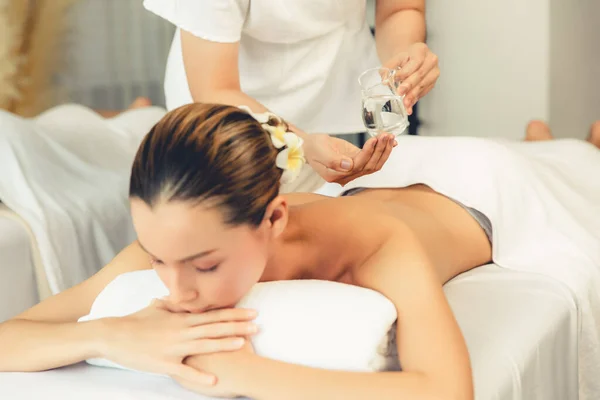 Masseur hands pouring aroma oil on couples back. Masseuse prepare oil massage procedure for customer at spa salon in luxury resort. Aroma oil body massage therapy concept. Quiescent
