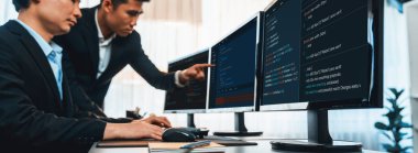 Yazılım geliştirme ekibi ofiste birlikte çalışıyor, bilgisayar ekranında betik görüntülemesi kodluyor. Teknoloji geliştirici şirketinde çalışan programcı ve yazılım mühendisi. Önde.