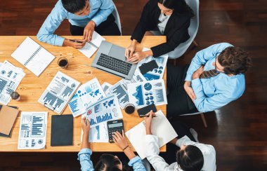 Panorama üst düzey iş analist grubu toplantı masasındaki finansal veri raporunu analiz ediyor. İş zekası analizine göre çizelge ve grafik paneli. Çok titiz.