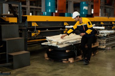 Mühendis, fabrika deposunda yeniden kullanım amaçlı sanayi ürünleri veya malzemelerini inceler ve yönetir. Verimli üretim için ağır endüstriyel ürünlerin kalite kontrol denetimi. Örnek gösteriliyor