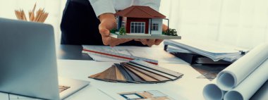 Çalışma masasının iç mimar tasarımcısı evin iç planlarını tasarlıyor ve ruh hali kurulu örneklerini seçiyor. Ev yenileme ya da tasarım konsepti için yaratıcı el çizimi planı. İçgörü