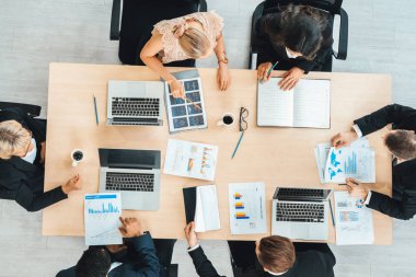 İş adamları grup toplantısı ofiste yukarıdan çekildi. İş kadınları, iş adamları ve ofis çalışanları toplantı masasında proje planlama belgeleriyle takım konferansında çalışıyorlar. Jivy