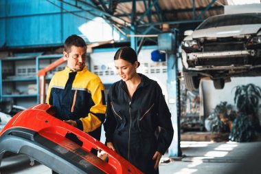 İki mutlu araç tamircisi, başarılı bir araba denetiminden ya da araba tamirinden sonra beşlik çaktı. Teknisyen ekibi garajda birlikte çalışmanın tadını çıkarıyor. Oxus.