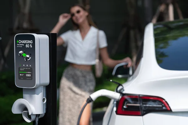 여성은 여름에 가능한 정원에서 자동차 Bev 내부의 깨끗한 충전식 에너지로 — 스톡 사진