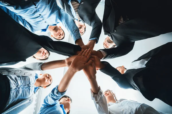 Multiracial business people make synergy hand stack together in meeting room as cooperation or team building for corporate employee in workplace. Closeup below view. Habiliment