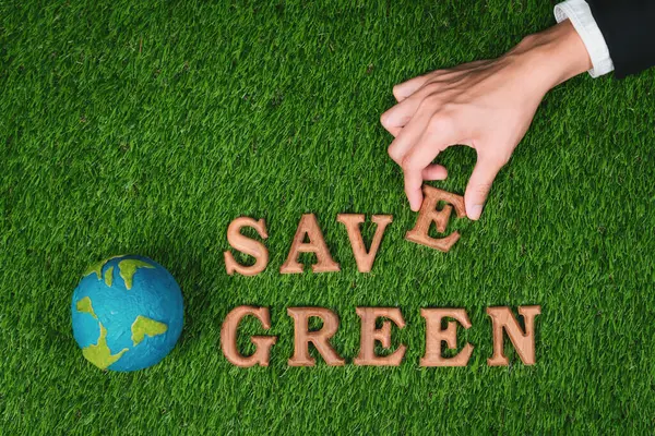 Hand arrange wooden alphabet in ecological awareness campaign with ECO icon design on biophilia green grass background to promote environmental protection for greener and sustainable future. Gyre