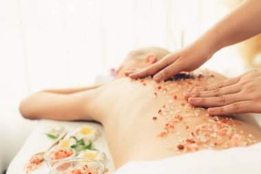 Lüks spa salonunda sıcak mum ışığı atmosferi olan kaplıca tedavisi gören kadın müşteri. Sağlık kaplıcasında güzellik tedavisiyle tuz temizliği. Sessiz.