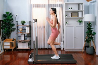 Evinde çalışan enerjik ve güçlü Asyalı kadın atletik yan bakış açısı. Formda fiziğin takibi ve ev çalışması ve eğitimle sağlıklı yaşam tarzına bağlılık. Kuvvetli