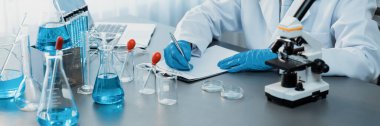 Aşı ilacı ya da antibiyotik için tıbbi laboratuvarda kimyasal deney yaptıktan sonra elde kaydedilen veriler yakından inceleniyor. Bilimsel kimya laboratuvarı ve tıp araştırma konsepti. Neoterik