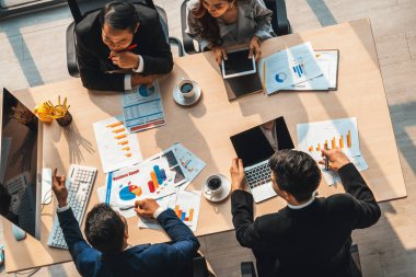 İş adamları grup toplantısı ofiste yukarıdan çekildi. İş kadınları, iş adamları ve ofis çalışanları toplantı masasında proje planlama belgeleriyle takım konferansında çalışıyorlar. Jivy