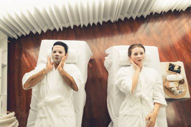 Kaplıca salonunun sakin, modern gündüz atmosferi, birkaç müşteri yüz maskesi takarak kendini yenilemeye çalışıyor. Yüz bakımı ve güzellik kozmetolojisi prosedürü. Sessiz.