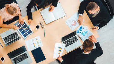 İş adamları grup toplantısı ofiste yukarıdan çekildi. İş kadınları, iş adamları ve ofis çalışanları toplantı masasında proje planlama belgeleriyle takım konferansında çalışıyorlar. Jivy
