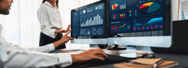 Analizci veri analizi ya da bilgisayar monitöründeki BI gösterge paneli üzerinde çalışıyor. Ticari pazarlama ve strateji planlaması için Fintech 'in şirket ofisindeki finansal verilerini analiz eden iş ekibi. Önde.