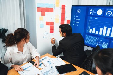 Finansal veri raporunu analiz eden çeşitli bir grup iş analisti. Mali veri analiz çizelgesi ve grafik paneli stratejik pazarlama planlama için toplantı odasında TV ekranında. Habiliment
