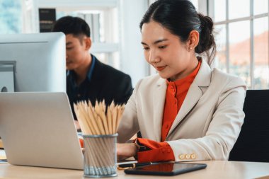 Modern ofis odasındaki masada çalışan iş adamları mali veri raporlarını incelerken. Jivy