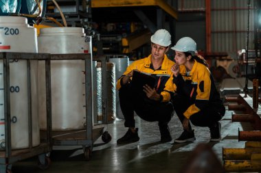 İki fabrika işçisi veya mühendis, kimya fabrikası, kimya fabrikası işyeri ve endüstriyel meslek konseptinde makine veya prosedür üzerinde profesyonel teftiş yürütüyor. Örnek gösteriliyor