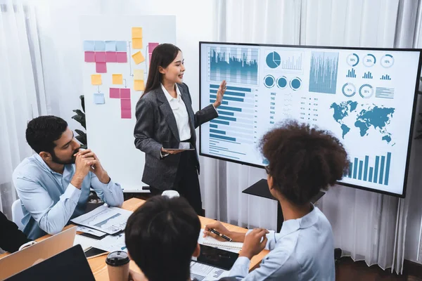 stock image Young asian businesswoman presenting data analysis dashboard on TV screen in modern meeting. Business presentation with group of business people in conference room. Concord