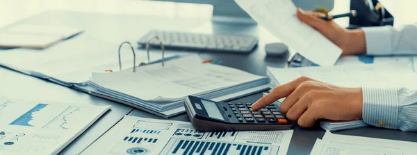 監査役は事務机の上で計算機で予算を計算する 会計事務所の専任会計士の専門家が財務書類を分析して収入を予測する — ストック写真