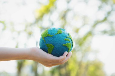 Dünya gezegenini ESG ilkesi ve çevre dostu enerjisiyle daha parlak bir gelecek için Dünya günü olarak el ele tutuşan genç çocuklar. Döngü