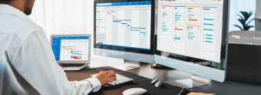 Proje yöneticisi, ekranda gantt grafik yazılım gösterimi kullanılarak ofis için iş programları planlıyor. Modern iş yönetimi ve iş akışı organizasyonu. Önde.