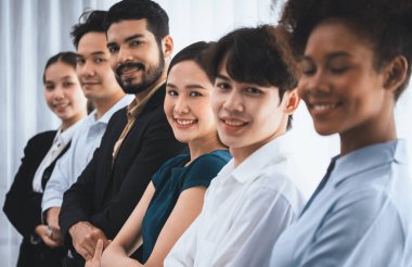 Mutlu ve gülümseyen çok ırklı ofis çalışanı, sinerjiyi ve ticari başarı için işbirliğini destekleyen bir kuyrukta el ele tutuşuyor. Modern işyerinde çeşitli profesyonel ofis çalışanları arasında bağ var. Uyum