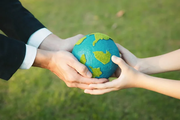 Businessman hand giving Earth globe to little boy as Earth day concept as corporate social responsible to contribute greener environmental protection for sustainable future generation. Gyre