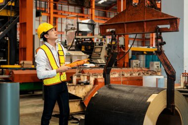 Makine operatörü çelik üretim makinelerini ustalıkla çalıştırıyor, metal fabrikasındaki ağır inşaat mühendisliği malzemeleri için silindir rulo çelik üretiyor. Örnek gösteriliyor