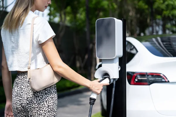 Giovane Donna Viaggiare Con Ricarica Auto Elettrica Nel Verde Sostenibile — Foto Stock