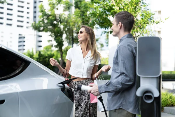 Junges Paar Reist Mit Elektroauto Aufladung Grünen Nachhaltigen Stadtgarten Sommer — Stockfoto