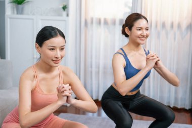 Egzersiz arkadaşı ya da antrenörü olan enerjik bir kadın evde egzersiz yapıyor. Genç atletik Asyalı kadın dayanıklılığı ve dayanıklılık antrenmanı..