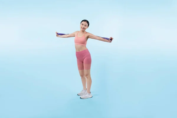 穿着运动服的精力充沛的女人伸展着抵抗运动乐队 年轻的亚洲女运动员力量和耐力训练课程在孤立背景下的日常锻炼理念 — 图库照片