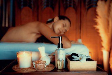 Aromaterapi masajı ambiyansı ya da spa salonu kompozisyon düzeneği bulanık kadınlara odaklı dekor mumları ve spa aksesuarları ile tatil köyü veya otel arka planında keyifli aroma spa masajı yapan. Sessiz.