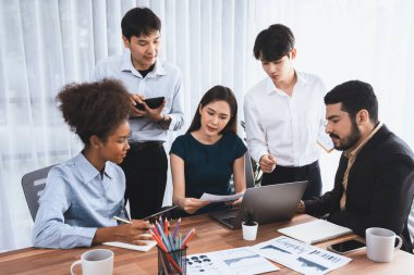 Çok ırklı analist ekibi toplantı masasındaki mali raporu analiz etmek için BI gösterge tablosunu kullanıyor. Çeşitli iş adamlarından oluşan bir grup, FIntech 'in veri analizini başarılı iş pazarlaması için kullanır. Uyum