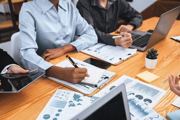 Команда мультирасовых аналитиков использует данные приборной панели BI для анализа финансового отчета в таблице заседаний. Группа различных деловых людей использует анализ данных FIntech для принятия маркетинговых решений. Конкорд