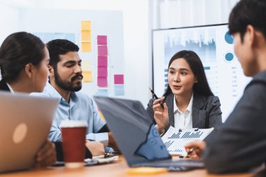 Genç Asyalı iş kadını modern toplantıda TV ekranında veri analizi paneli sunuyor. Bir grup iş adamıyla konferans odasında iş sunumu. Uyum