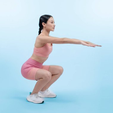 Egzersiz yapan enerjik bir kadın. Genç atletik Asyalı kadın gücü ve dayanıklılık antrenmanı rutin antrenman olarak. Tüm vücut stüdyosu izole edilmiş arka planda çekilmiş..