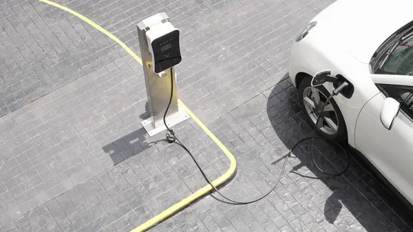 Progressive innovation urban electric on-street charging station with electric vehicle battery being charged with green energy for environmental concern in order to reduce CO2 emission.