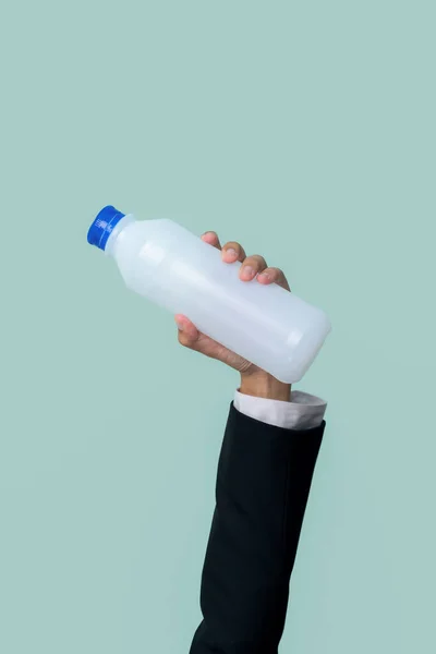 Businessmans hand holding plastic bottle on isolated background. Eco-business recycle waste policy in corporate responsibility. Reuse, reduce and recycle for sustainability environment. Quaint