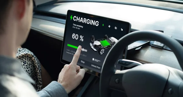 电动汽车司机检查电池充电状态 范围和收费限制在应用屏幕上的汽车 智能技术装置显示了电动汽车蓄电池内部蓄电充电数据 — 图库照片