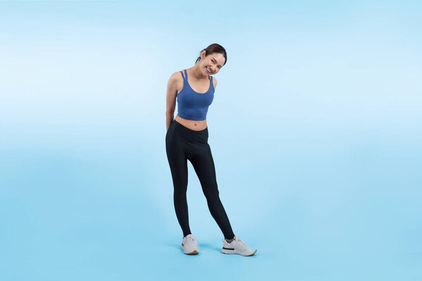 Все тело азиатки в спортивном портрете, улыбаясь и позируя веселый жест. Тренировки с привлекательной девушкой занимаются ее стремлением к здоровому образу жизни. Изолированный фон