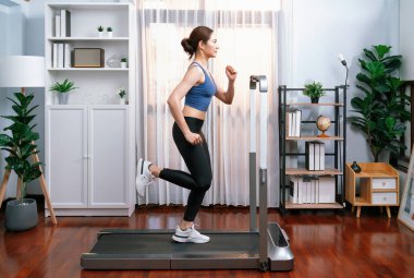 Evinde çalışan enerjik ve güçlü Asyalı kadın atletik yan bakış açısı. Formda fiziğin takibi ve ev çalışması ve eğitimle sağlıklı yaşam tarzına bağlılık. Kuvvetli