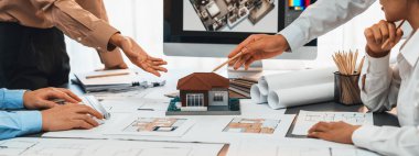 İç mimar tasarımcı grubu, daha kesin tasarım için planlar ve dizüstü bilgisayar ekran mimari yazılımı üzerinde birlikte tartışıyorlar. Modern ev tasarımı ve yenileme. İçgörü