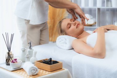 Kafkasyalı kadın stres önleyici kafa masajından ve lüks tatil beldesi ya da otel spa salonundaki modern ışık ortamında yüz güzelliği eğlencelerini şımartmaktan hoşlanıyor. Sessiz.