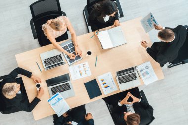 İş adamları grup toplantısı ofiste yukarıdan çekildi. İş kadınları, iş adamları ve ofis çalışanları toplantı masasında proje planlama belgeleriyle takım konferansında çalışıyorlar. Jivy