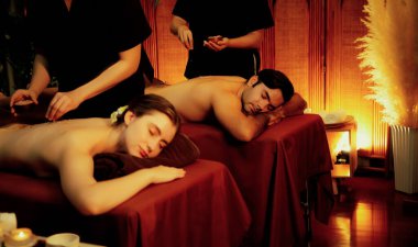 Lüks spa salonunda sıcak mum ışığı olan bir yerde deri dökülmesi tedavisi gören çift. Sağlık Spa vücut fırçasında tuz temizleme güzellik tedavisi. Sessiz.