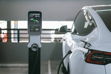 Alış veriş merkezinin otoparkında EV elektrikli araba şarjı şehir merkezindeki sürdürülebilirlik yaşam tarzını yeşil, temiz, yeniden şarj edilebilir elektrikli araç iç organları ile gösteriyor.