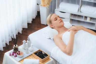 Kafkasyalı kadın müşteri stres önleyici spa masajının keyfini çıkarıyor ve lüks otel ya da oteldeki gündüz açık ortam güzellik salonunda güzellik teniyle eğleniyor. Sessiz.